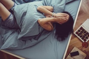 woman on bed with menstrual cramps