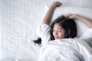 self care during your period - woman waking up in bed